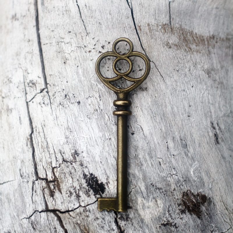 an old key is sitting on a piece of wood